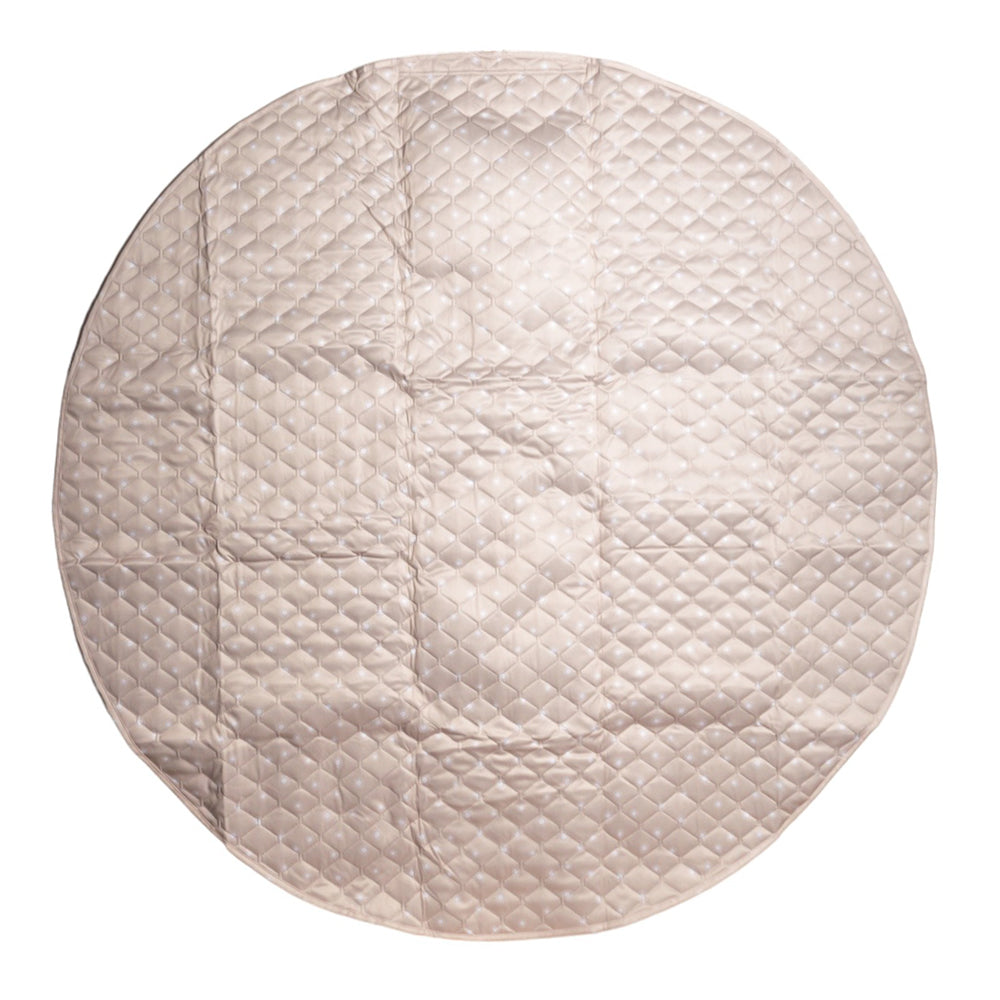 A round quilted fabric pad or mat in a light beige or champagne color, featuring a diamond-quilted pattern and shown flat against a white background.