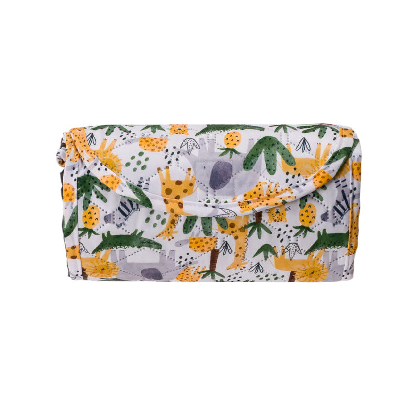 A folded kids play mat with a flap closure, featuring a playful safari print of yellow giraffes, green palm trees, and purple foliage on a white background.