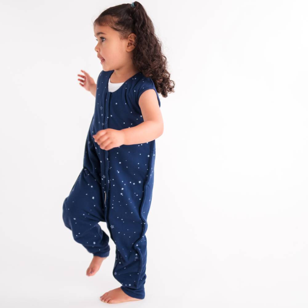 Child wearing a navy blue onesie with star patterns on a white background