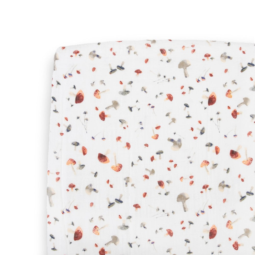 white cotton muslin fitted sheet with mushroom pattern on a bed with a white background