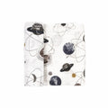 A white cotton muslin swaddle blanket with space-themed patterns on a white background