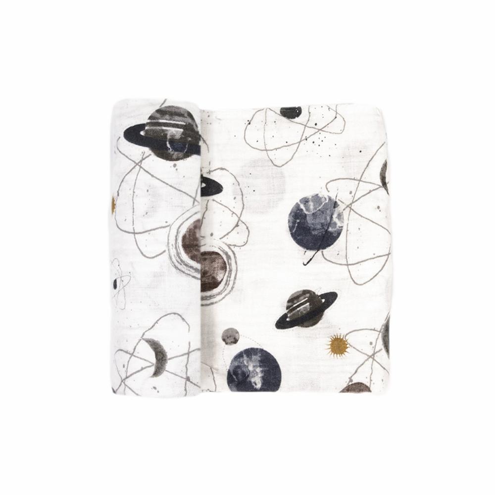 A white cotton muslin swaddle blanket with space-themed patterns on a white background