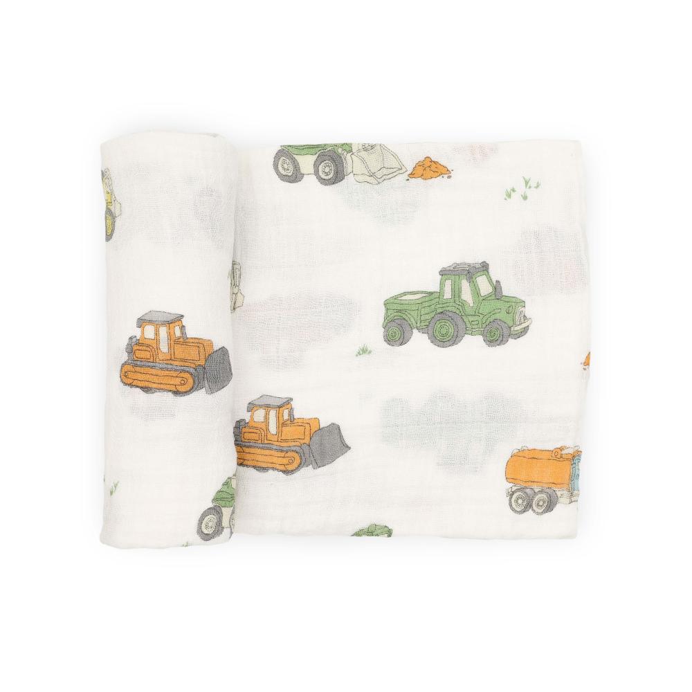 White muslin swaddle blanket with construction vehicle pattern on a white background