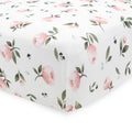 White floral patterned fitted sheet with pink flowers and green leaves on a white background