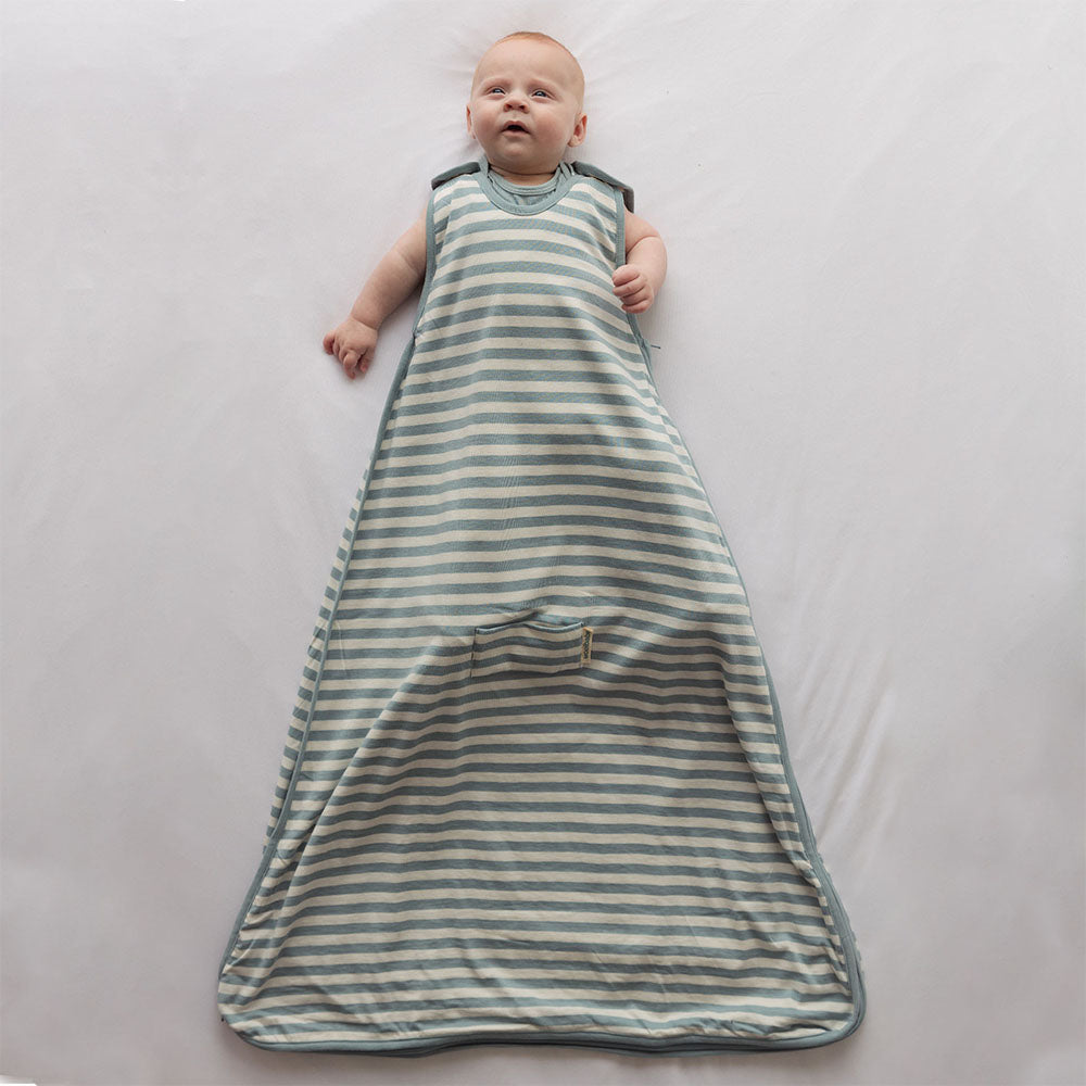 Baby lying on a plain surface wearing Woolbabe 3 Seasons Hip Dysplasia Sleeping Bag