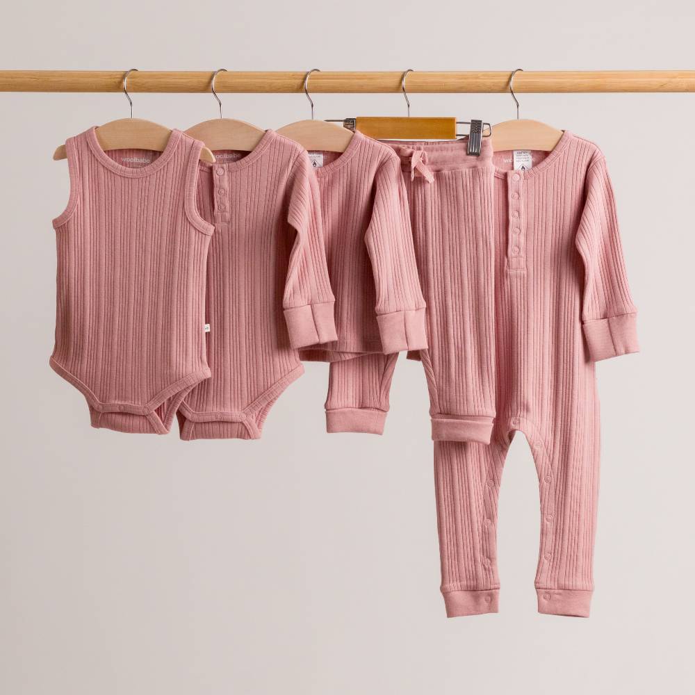 Dusk pink woolbabe collection hanging on a rail