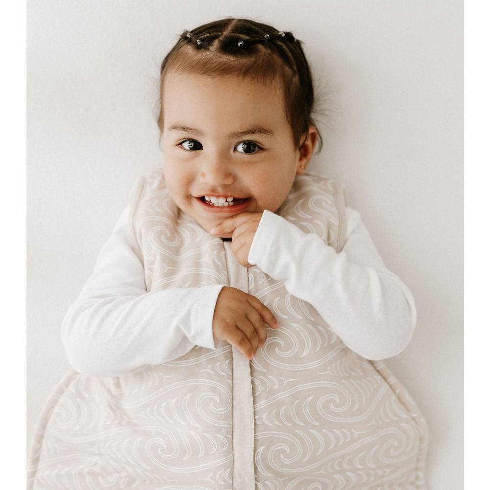 Child wearing a white quilted jacket with a subtle pattern on a plain background