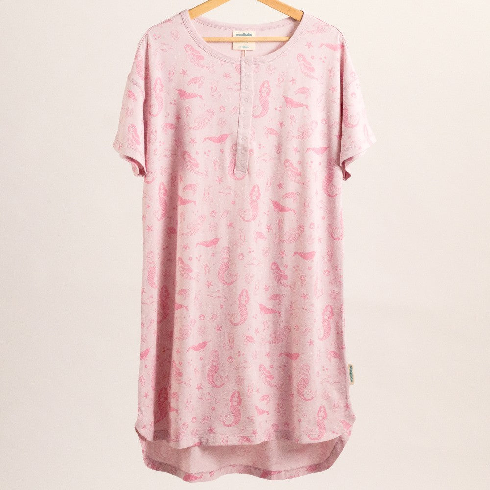 Pink dress with breastfeeding access snaps and mermaid print on a hanger against a white background