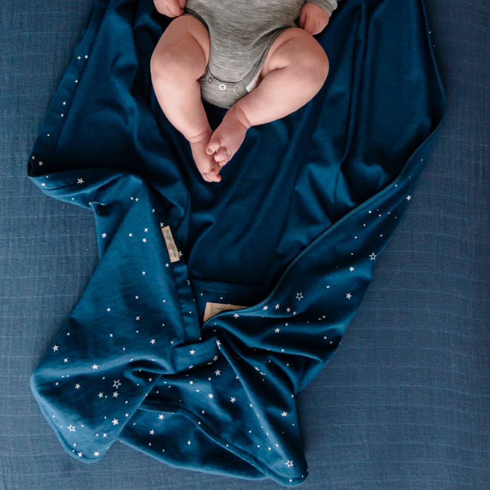 Baby lying on a blue blanket with star patterns