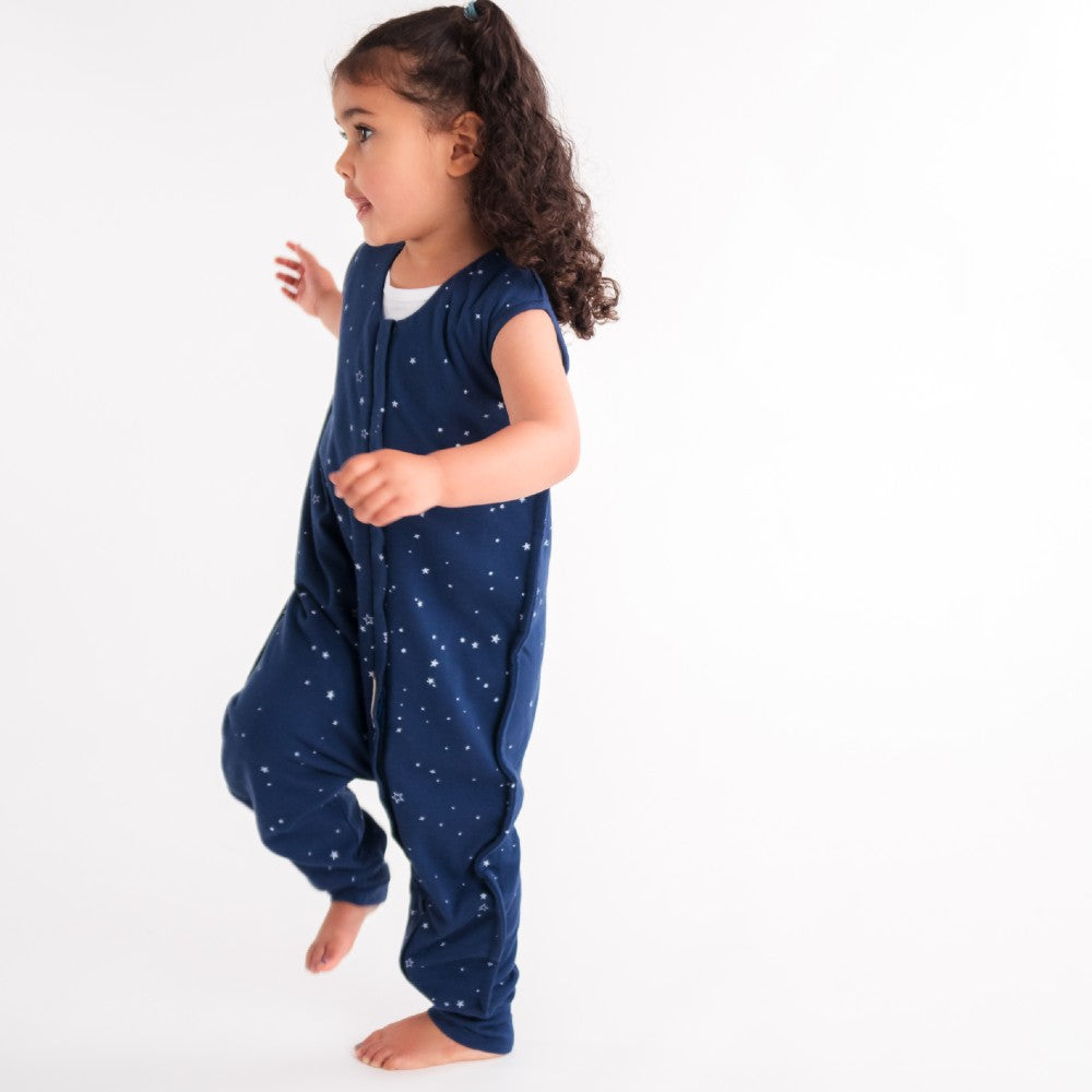 Child wearing a navy blue onesie with star pattern on a white background