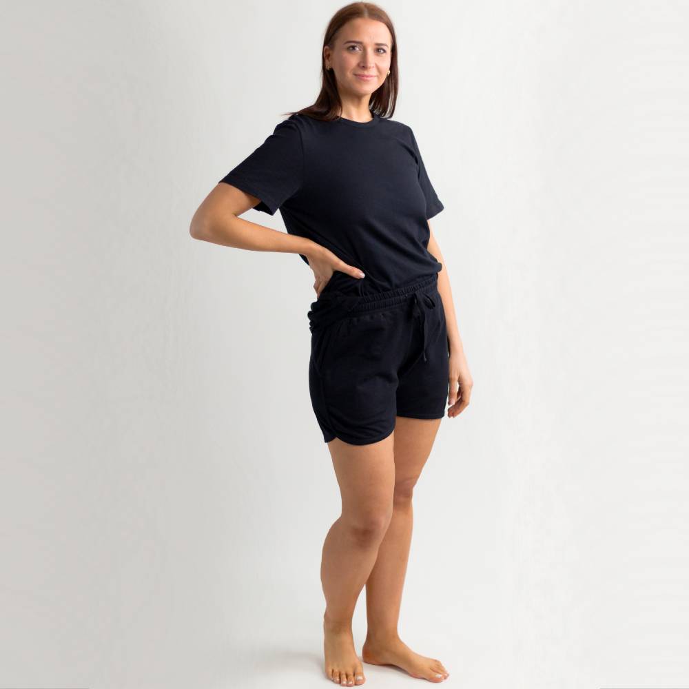 Woman wearing a black merino PJs on a white background