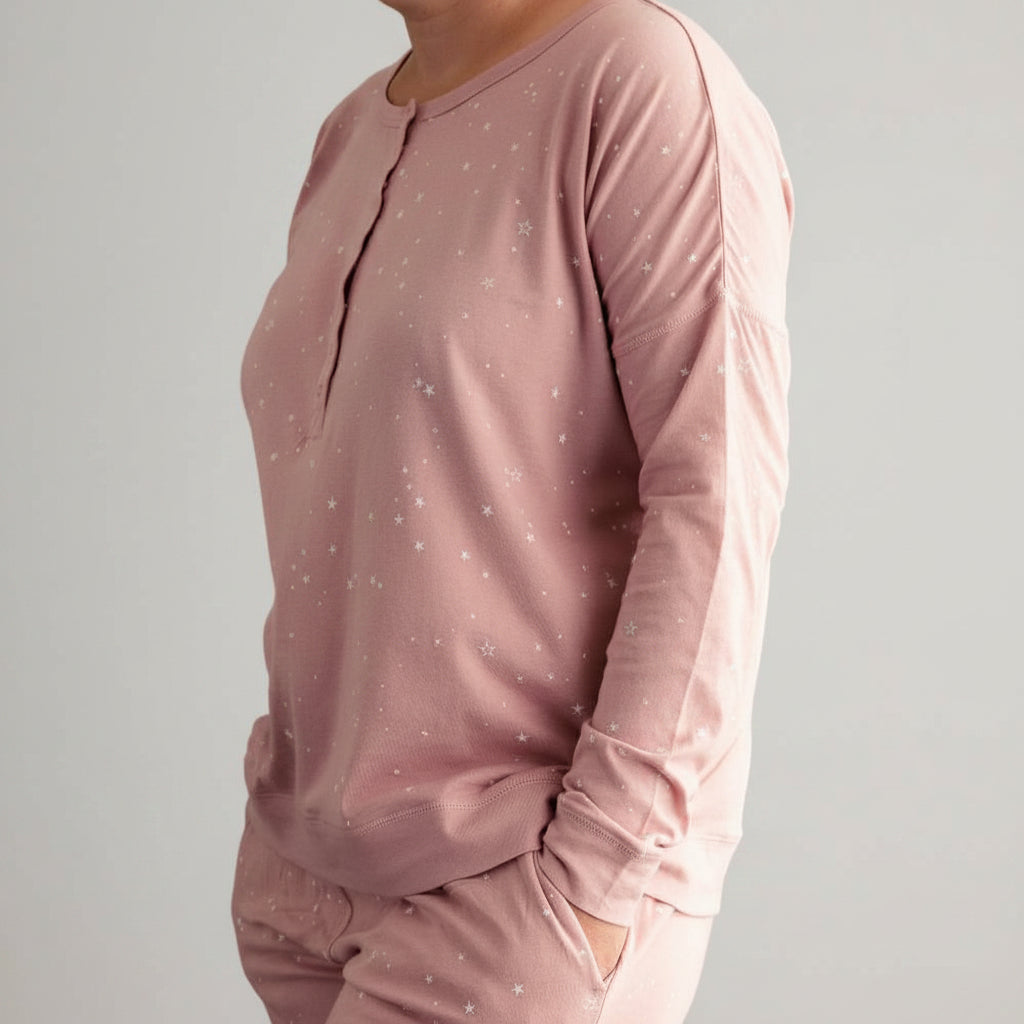 Pink long-sleeve top with star patterns on a dark blue background