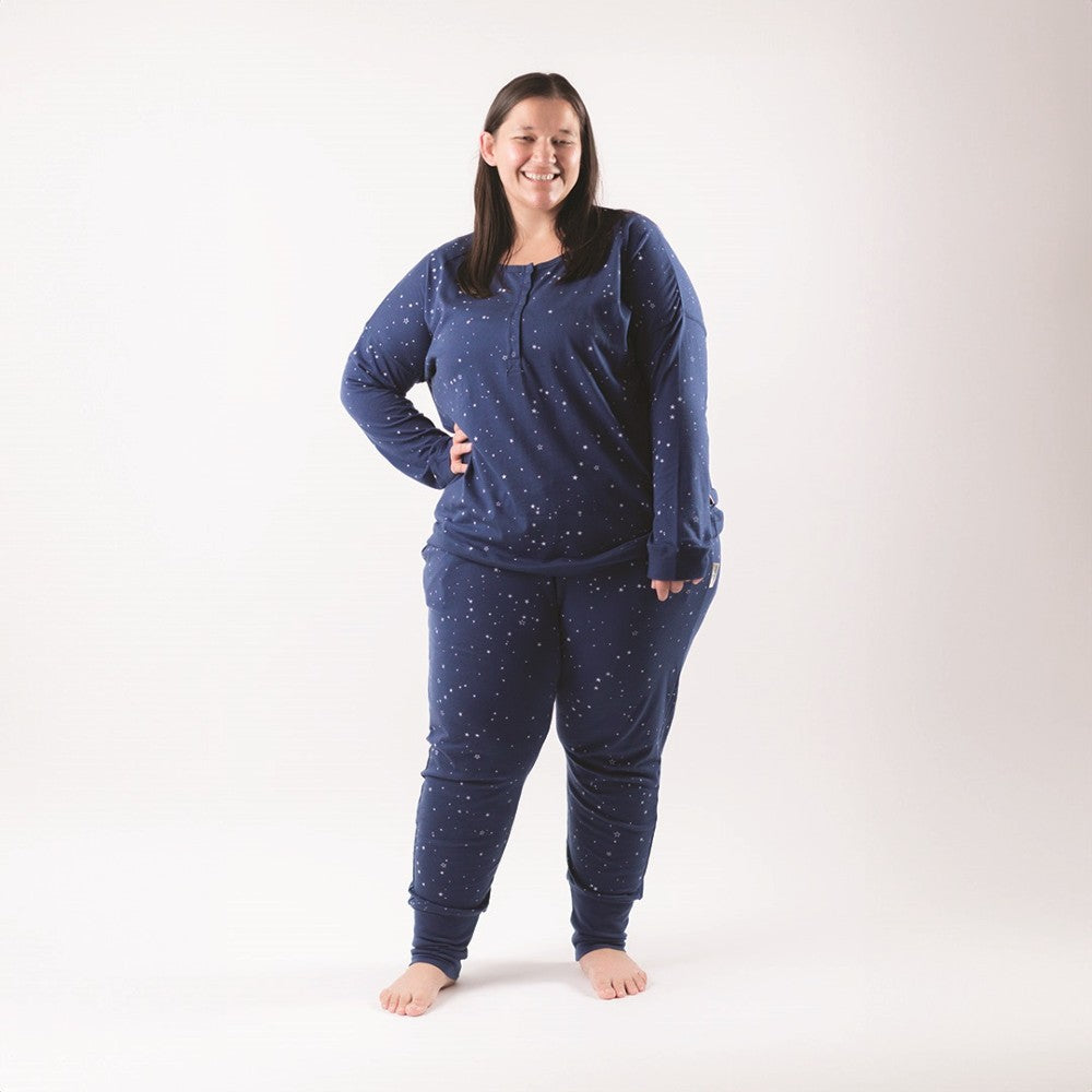 Woman wearing a blue pajama set with star pattern on a white background