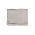 Folded gray woolbabe swaddle blanket on a white background