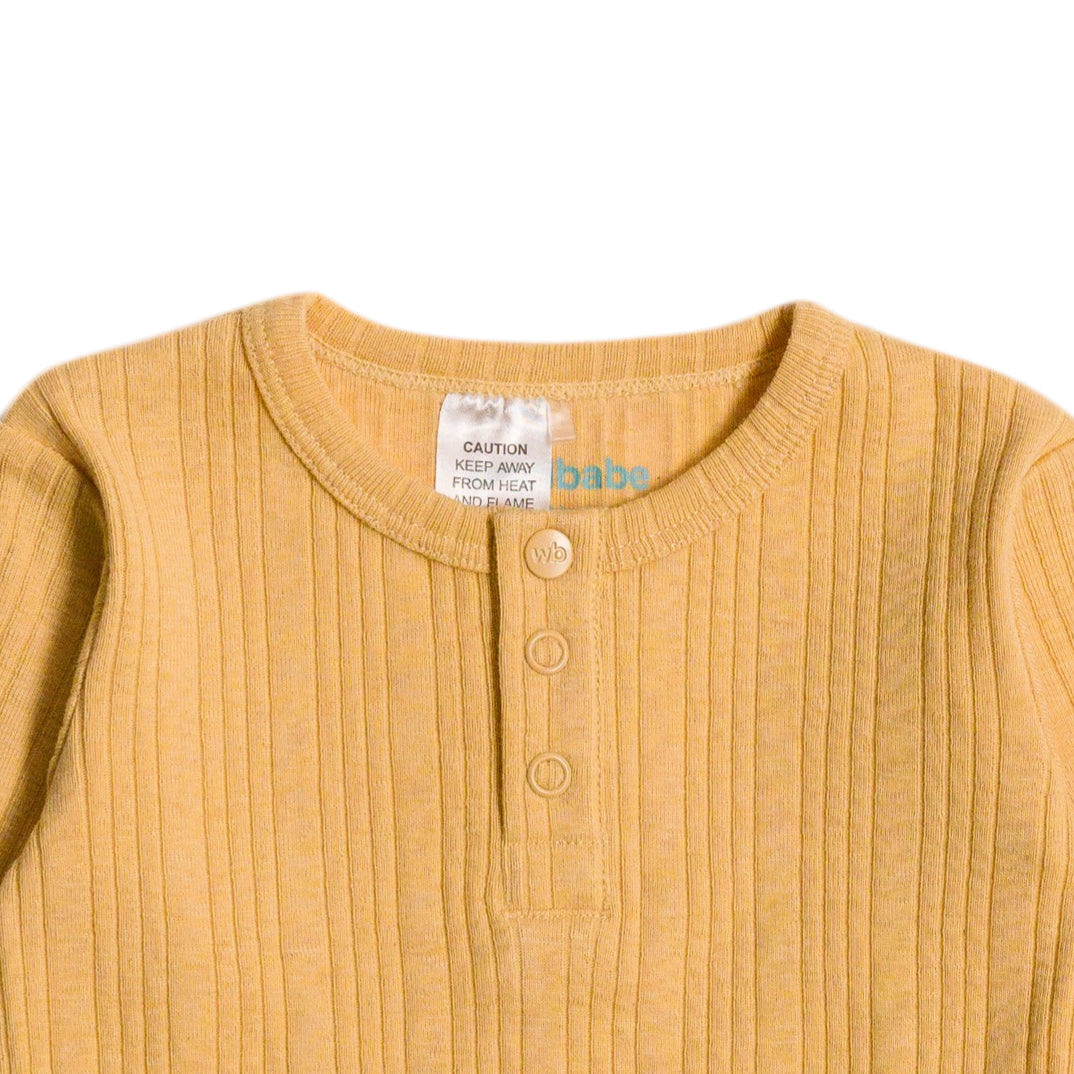 Yellow baby outfit with a label on a white background