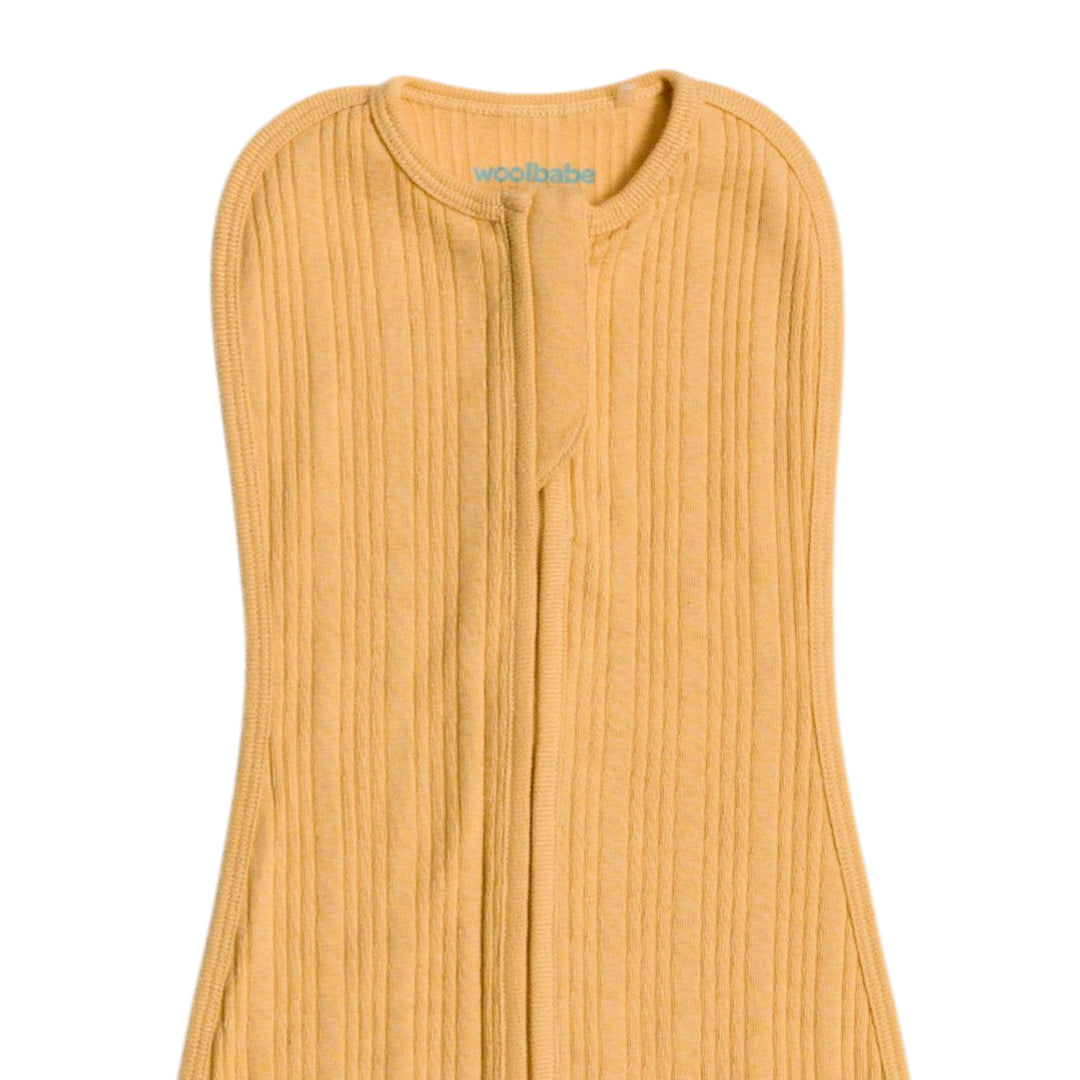 yellow woolbabe zip swaddle on a plain background