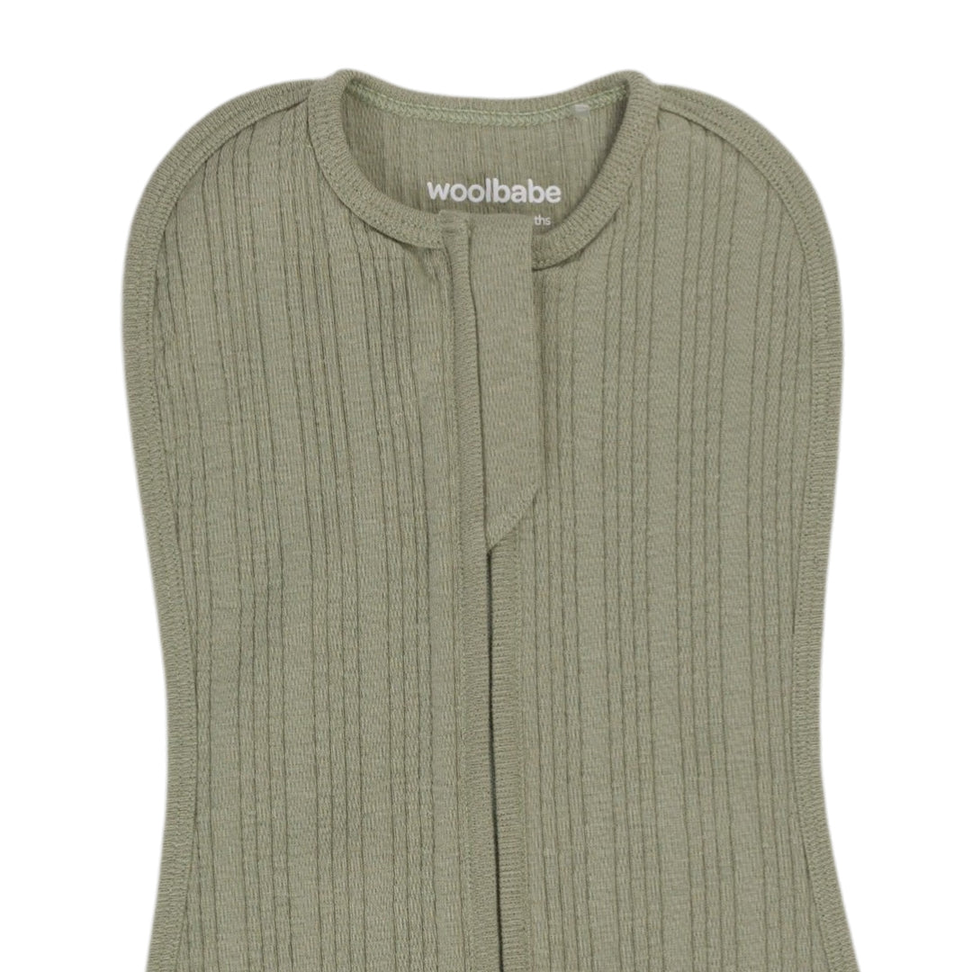 Green ribbed baby zip swaddle with 'woolbabe' branding on a white background