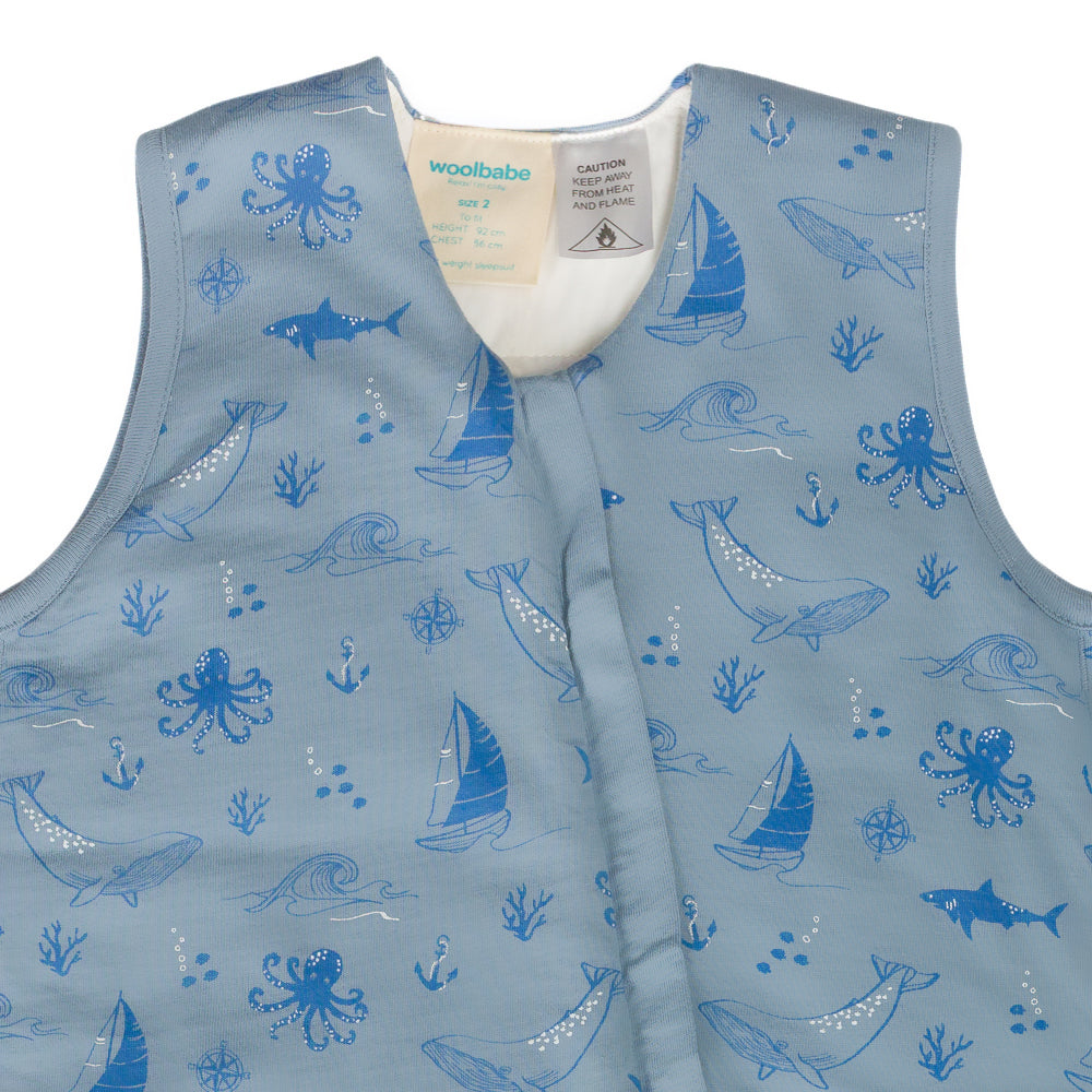 Children's quilted merino sleepsuit with blue ocean-themed pattern on a white background