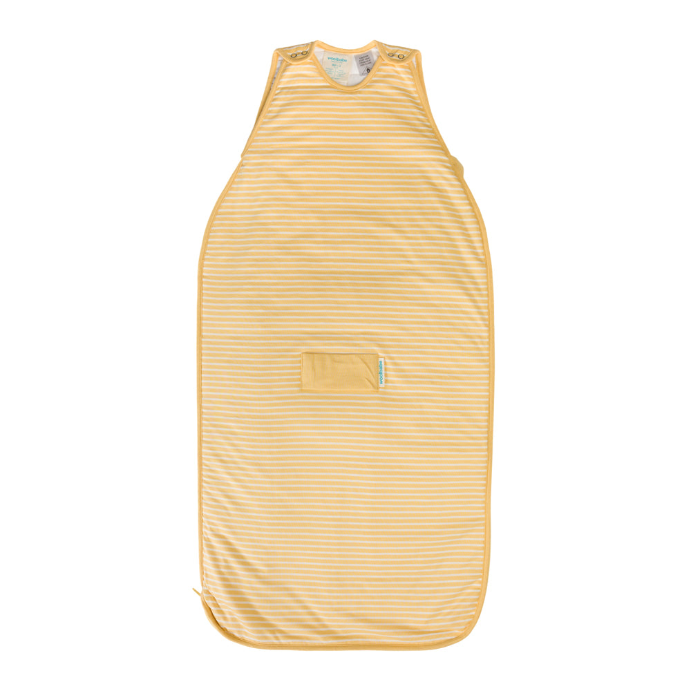 A woolbabe baby sleep sack in a pale yellow and white stripe pattern, featuring a small front pocket and a soft neck opening, shown flat against a white background.
