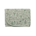 Folded swaddle blanket with green dinosaur and plant pattern on a light gray background