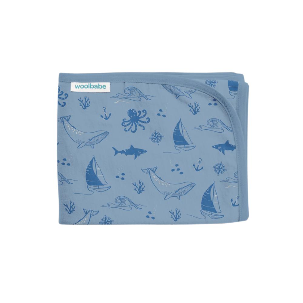 Blue baby blanket with ocean-themed pattern on a white background