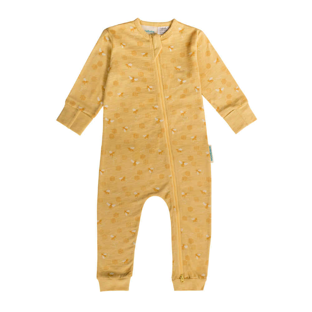 Yellow woolbabe PJ Suit onesie with a bee pattern on a white background