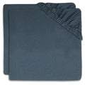 Two folded dark slate blue fitted sheet covers with elasticized corners, stacked on a white background.