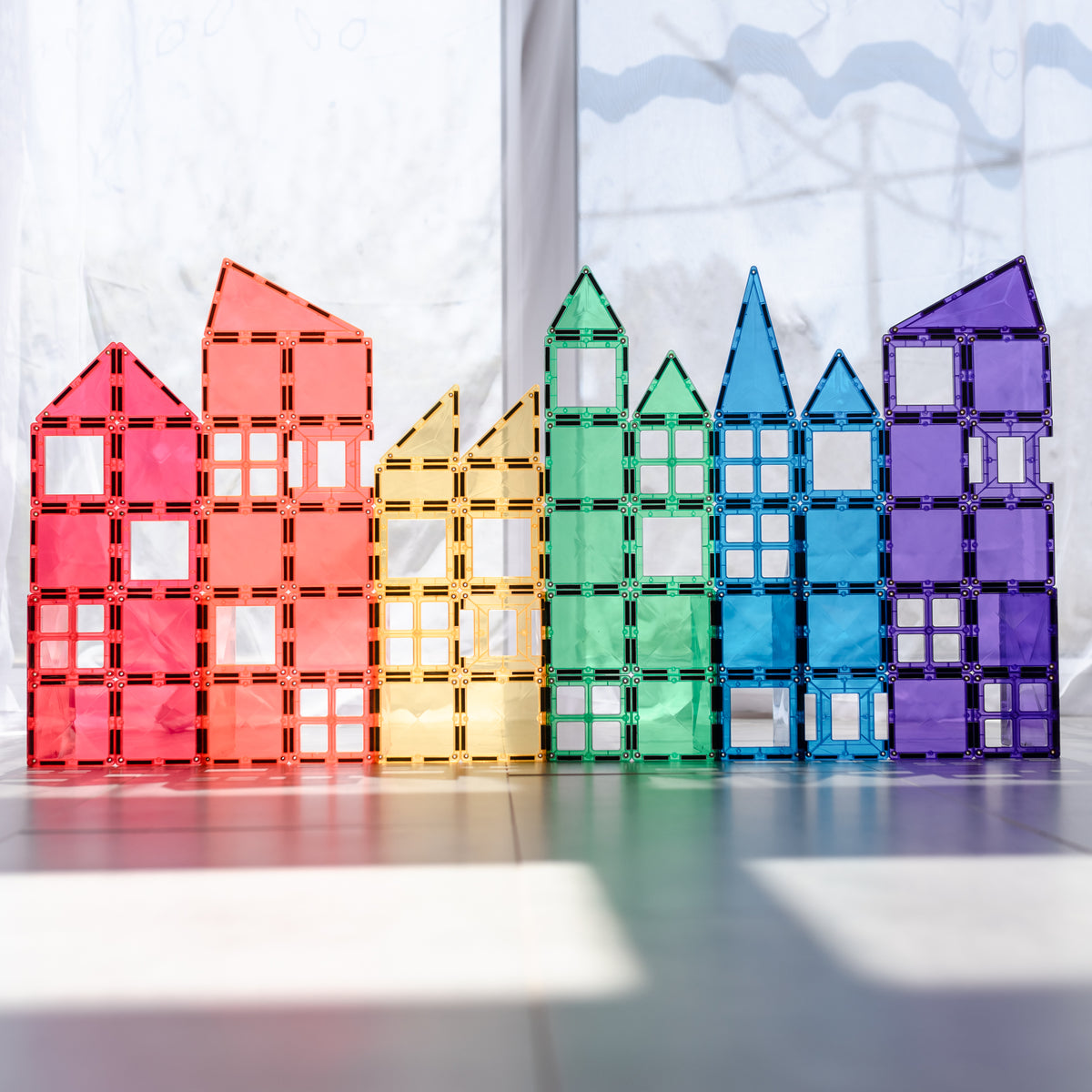 Colorful toy Connetix on a reflective surface with a light background