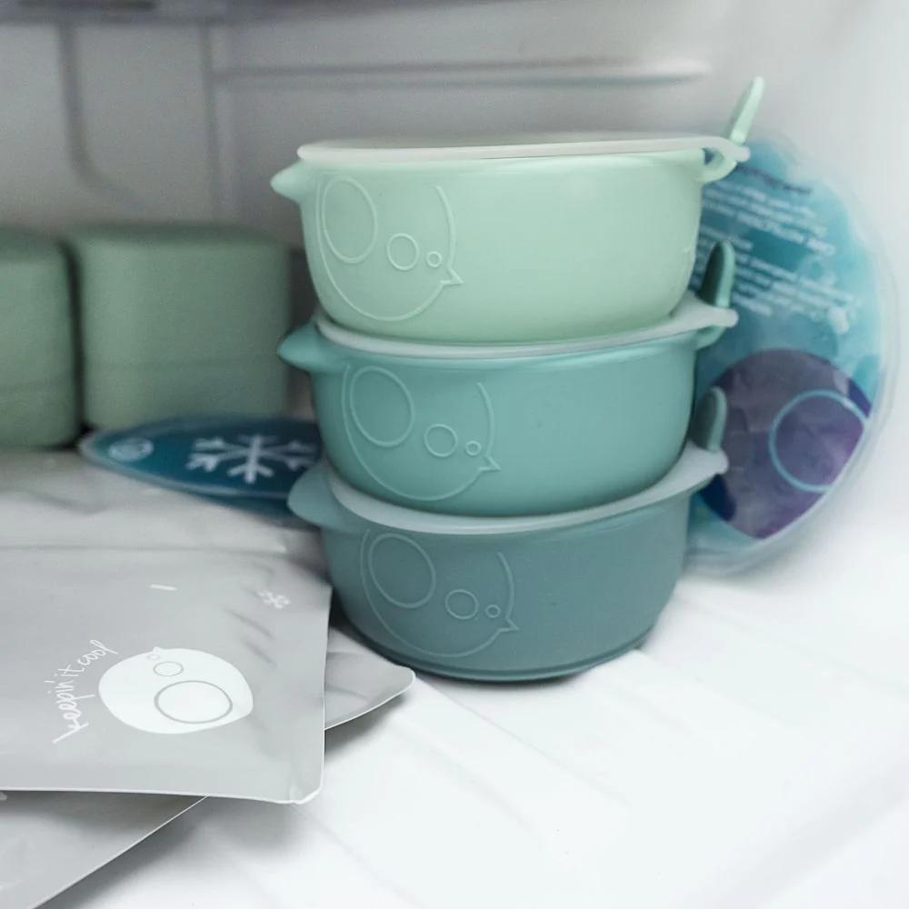 Stack of green silicone bowls in a freezer.