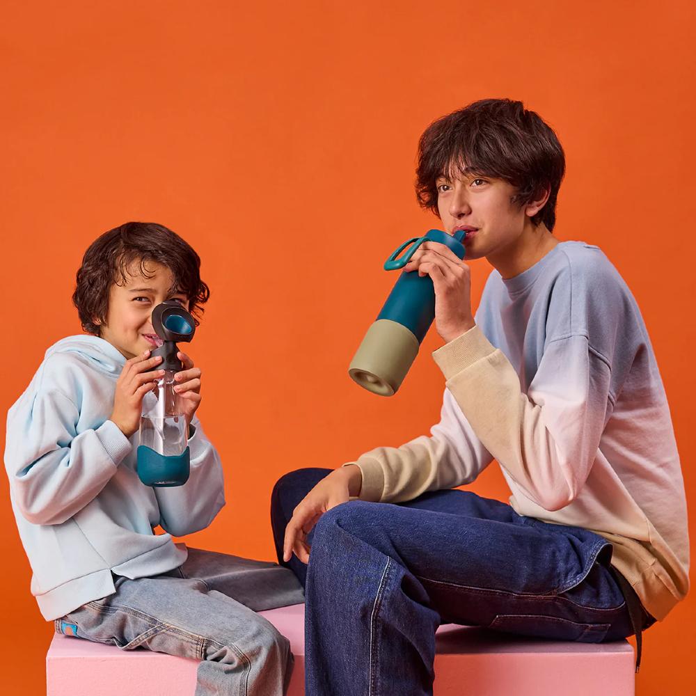 Two people with drink bottles against an orange background