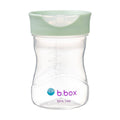 Clear b.box sippy cup with a green lid on a white background