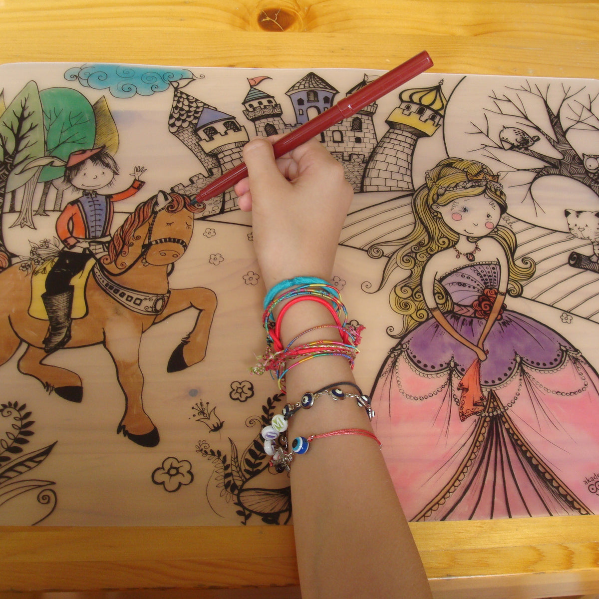 Child colouring the re-usable drawing mat with felts on a table 