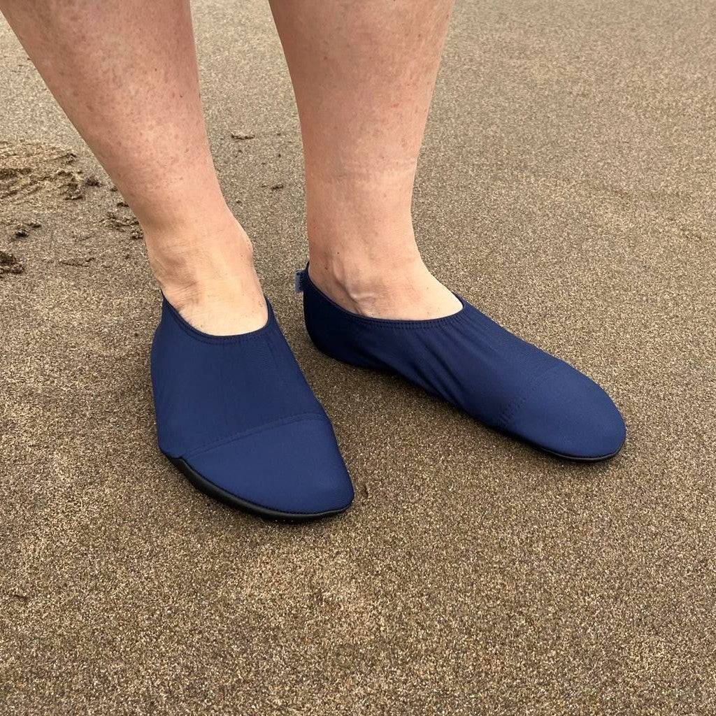 Blue slipfree shoes worn on a sandy surface