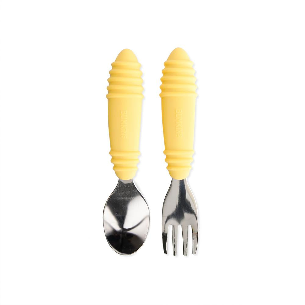 Stainless steel spoon and fork with yellow silicone handles on a white background