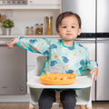 A long sleeve bib with elasticated wrists and front pocket in ocean life chevron pattern and bumkins tag