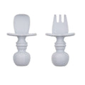 A grey set of silicone baby cutlery chewtensils including one spoon and one fork with bumkins logo on the handle 