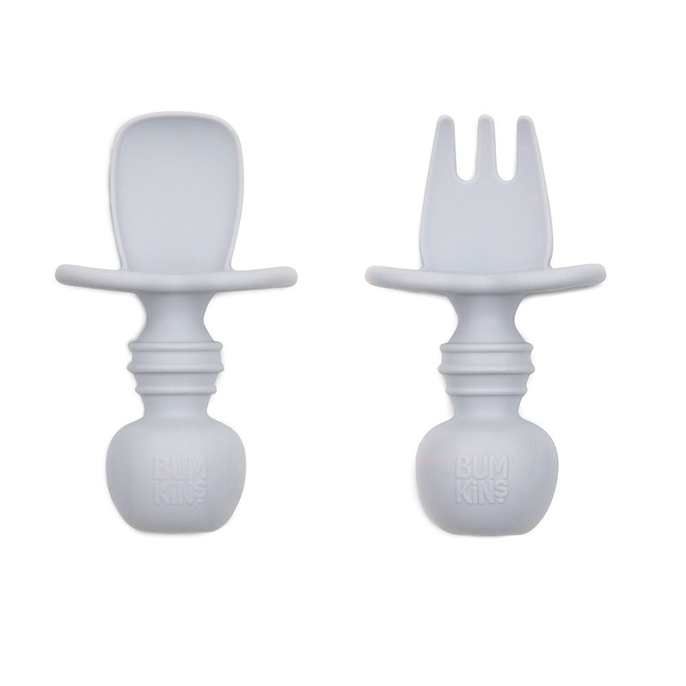 A grey set of silicone baby cutlery chewtensils including one spoon and one fork with bumkins logo on the handle 