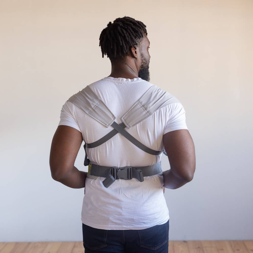 Person wearing a gray back brace against a plain background