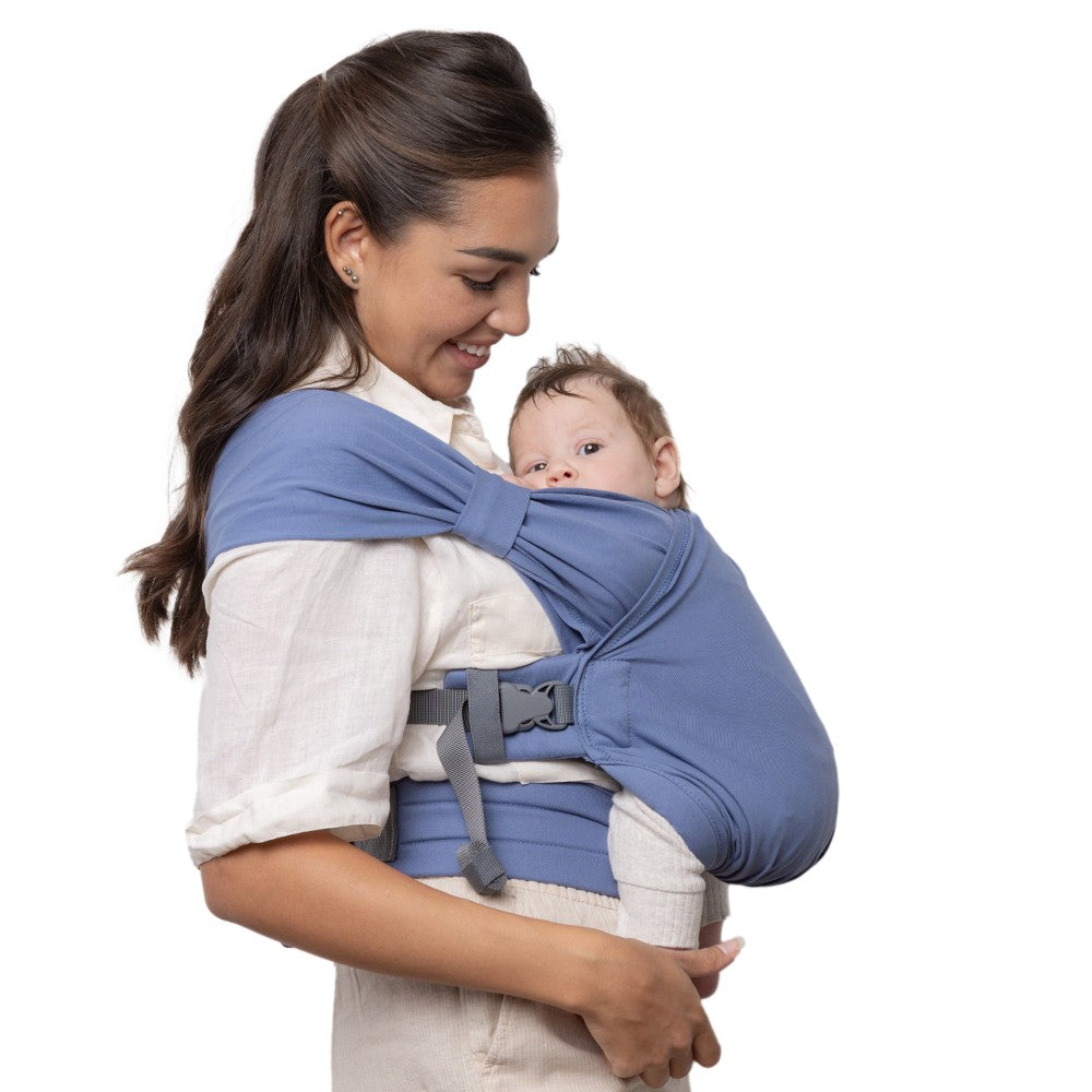 Woman carrying a baby in a blue baby carrier on a white background