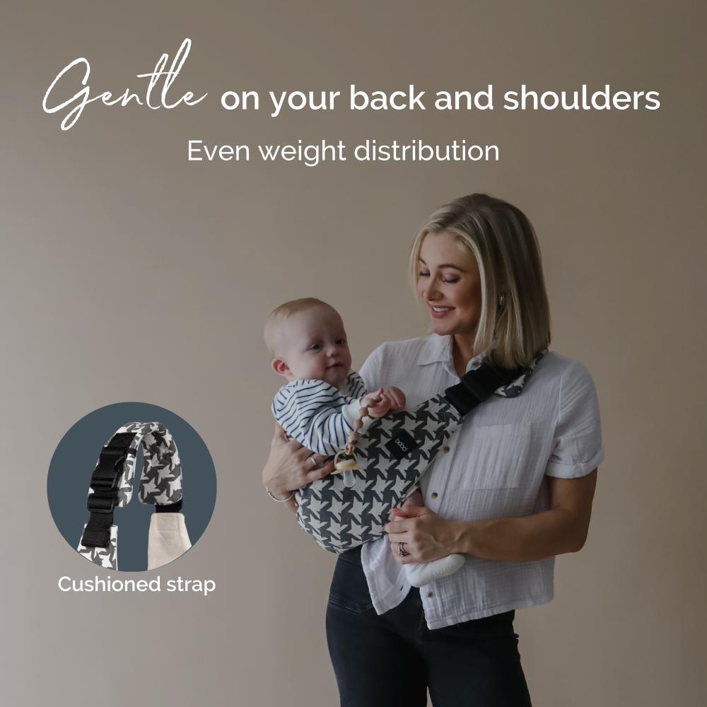 Woman holding a baby using a carrier assist hip sling with text about even weight distribution and cushioned strap.