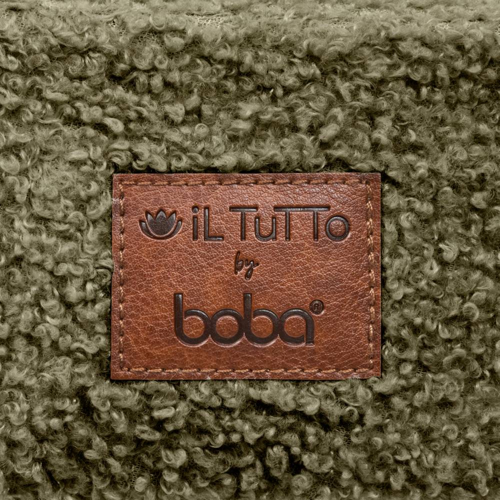 Close-up of a textured green fabric with a brown leather label reading 'il Tutto by boba'.