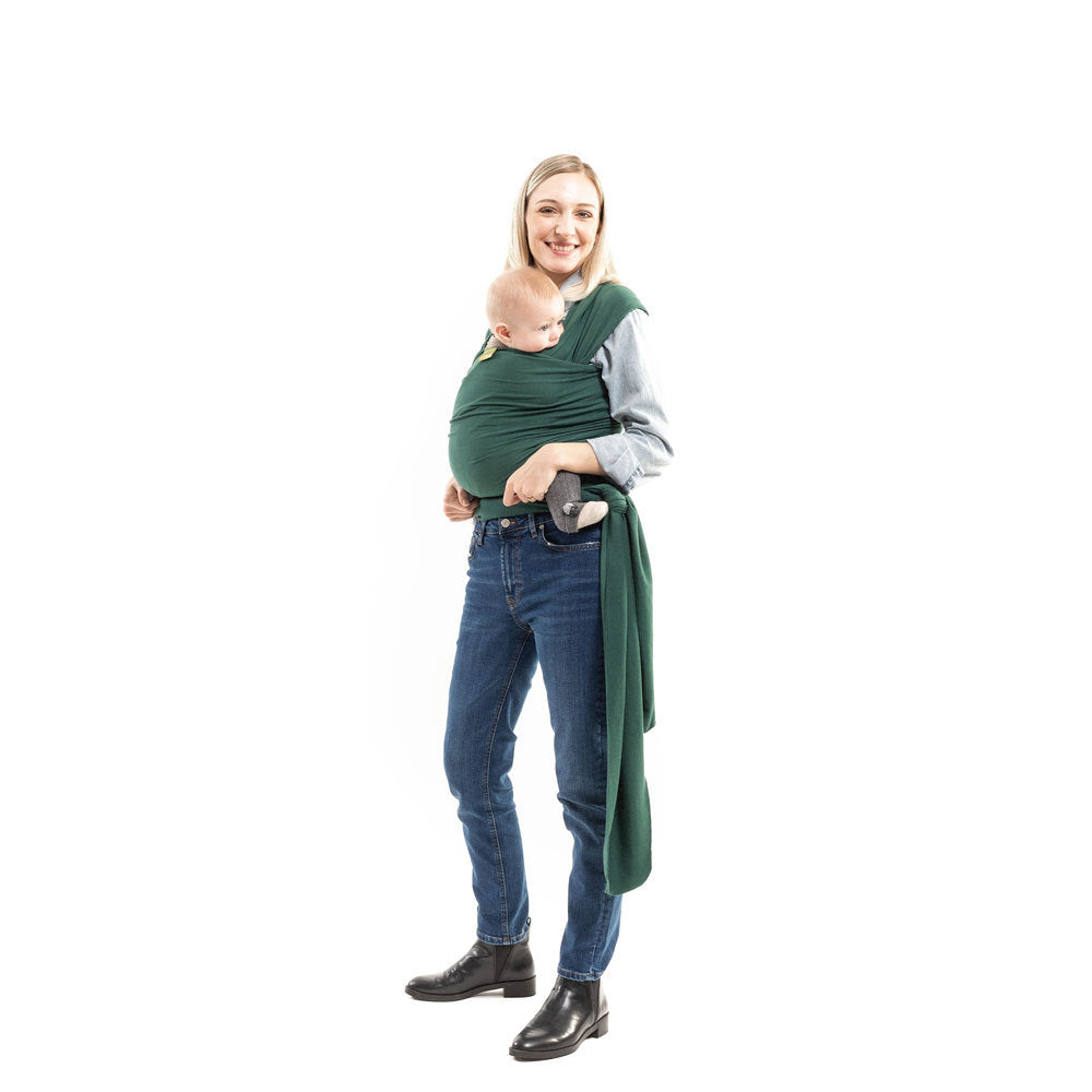 Woman wearing a baby in a green wrap on a white background