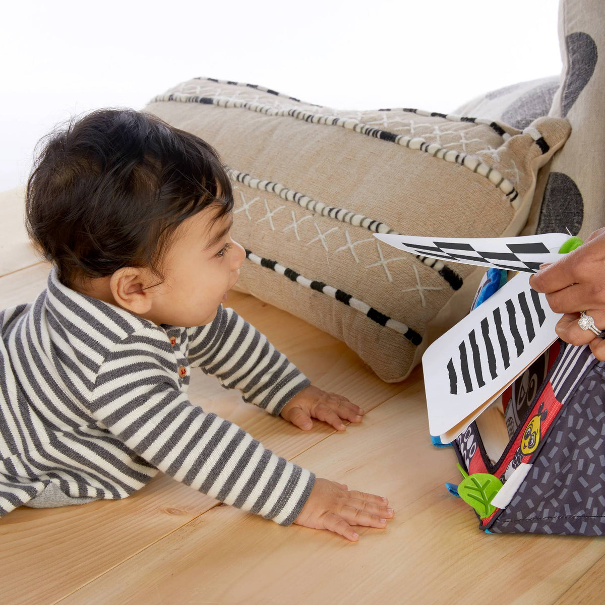 A baby lying on their tummy looking at the flashcards. 