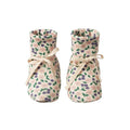 Pair of organic cotton cream and pink/purple/green floral baby booties with calico bows on a white background