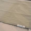 A close-up of a quilted moss green brolly sheet with a stitched grid pattern  with a white brand tag reading 'Brolly Sheets' visible near the bottom edge.
