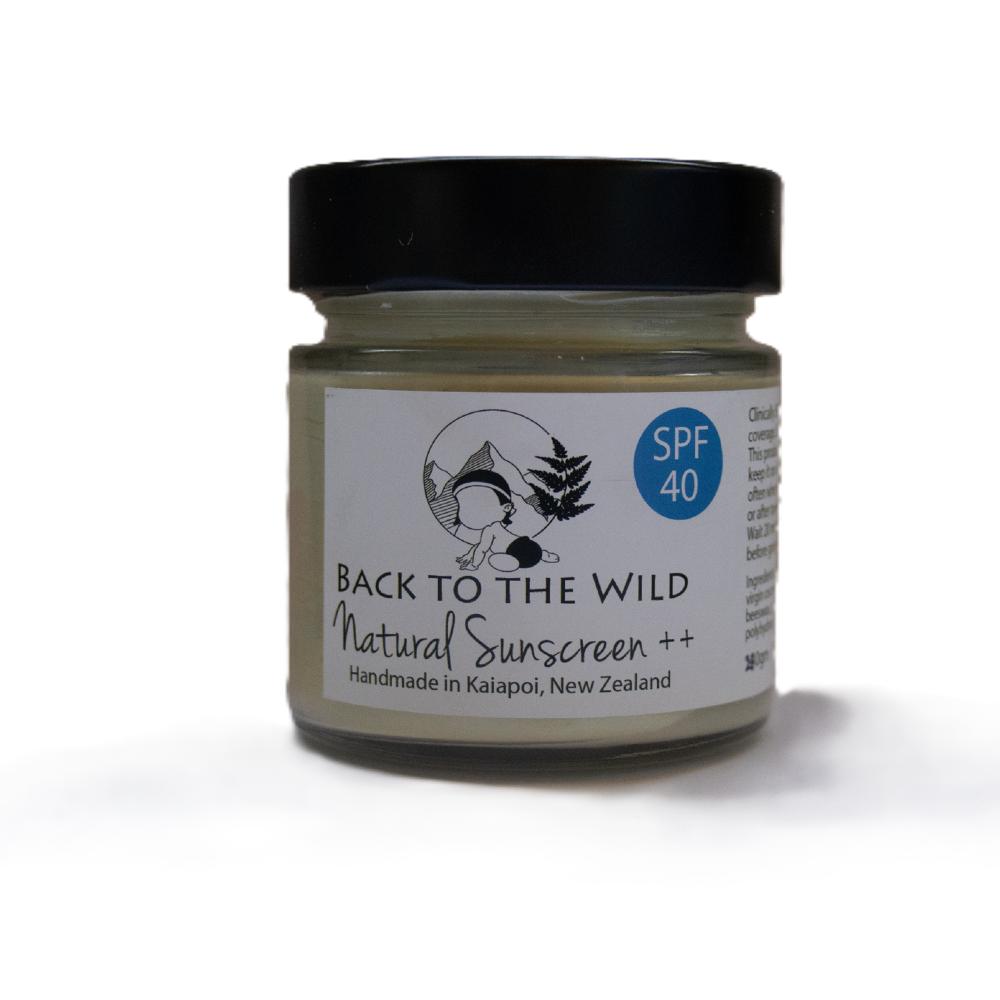 A jar of Back to the Wild Natural Sunscreen ++ with a black lid and a white label, set against a plain white background.