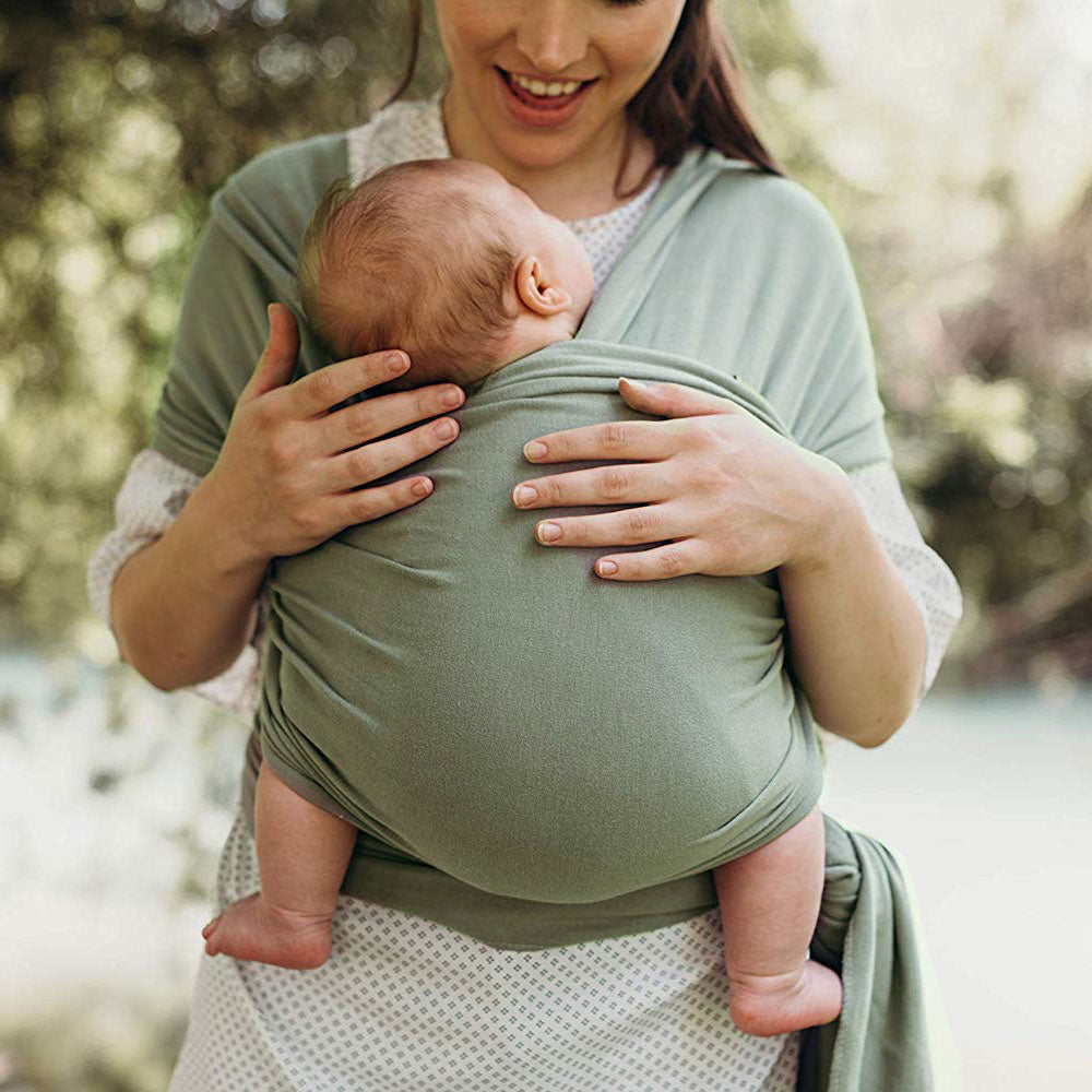 Woman holding a baby in a greenish grey Boba wrap carrier