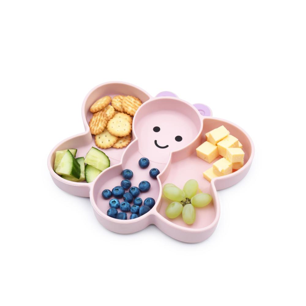 Pink bear-shaped divided plate with compartments filled with snacks on a white background