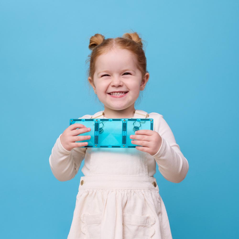 Child holding a blue Connetix blocks against a blue background