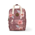 A dusty rose pink floral backpack with cream-colored top handles, featuring a front pocket with a snap button and a circular brown logo patch on the front.